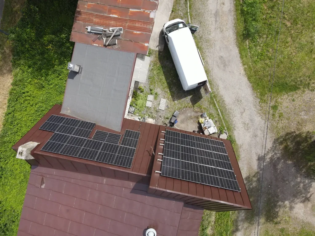 Widok z lotu ptaka na instalację fotowoltaiczną na budynku w Skoczowie, wraz z fragmentem podjazdu i otoczenia.